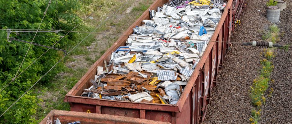 Above view of railway cargo train wagon filled by old rusty black metal scrap garbage forfactory plant recycling. Steel waste collecting, disposal transportation logistics. Environmental protection.