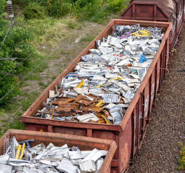 Above view of railway cargo train wagon filled by old rusty black metal scrap garbage forfactory plant recycling. Steel waste collecting, disposal transportation logistics. Environmental protection.